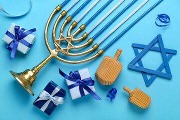Menorah with dreidels, David star and gifts for Hanukkah celebration on blue background