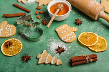 Fototapeta na wymiar Tasty Christmas cookies, cutters and ingredients on color background