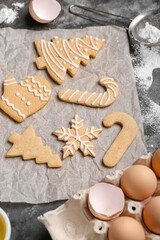 Fototapeta na wymiar Sheet of baking paper with tasty Christmas cookies on table, closeup