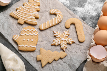 Sheet of baking paper with tasty Christmas cookies on table, closeup