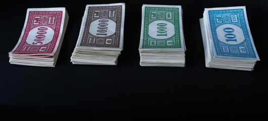 Stack of fake banknotes on black background.