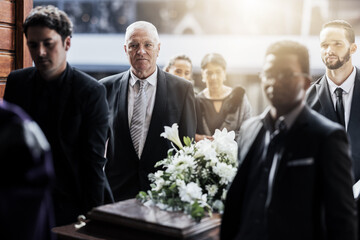 Sad, funeral and people with coffin at church for service, mourning and grief over death. Flowers, depression and ceremony with family carrying casket in chapel for sorrow, support and loss together - obrazy, fototapety, plakaty