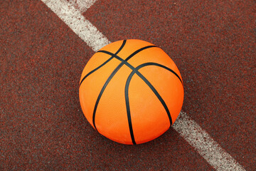 One basketball ball on playground rubber coating