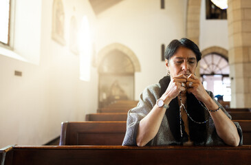 Pray, church and senior woman praying with a rosary in a calm, zen chapel alone, holy and...
