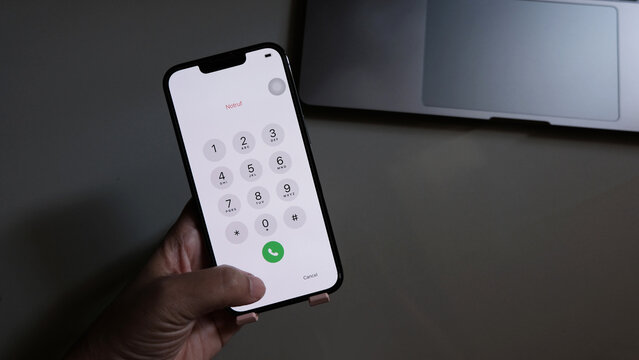 hand holding smartphone while entering the passcode.
