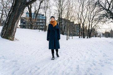 A cheerful young woman walks through a winter city