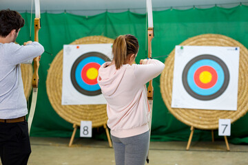 man and woman practicing archery