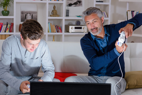 Man and adolescent playing computer game