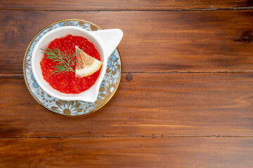 Luxury Red caviar in white plate  on white wooden background, Close up caviar in white plate.