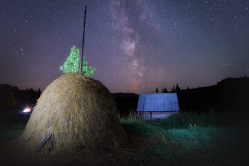 milky way and myriads of stars in a haystack on the outskirts of a village on a summer night