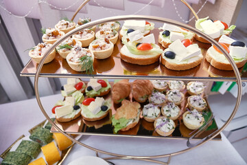 Buffet table with sandwiches, canapés and fruit.