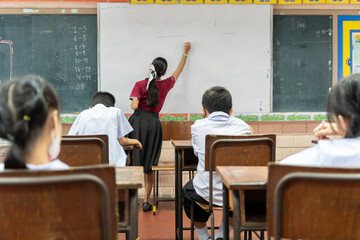 Educator uses white board, gives short presentation,  children some questions. Back to school concept