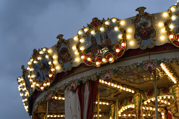 New Year's atmosphere in the city, festive carousel on the square. Festive Christmas tree decorated with garlands and balls. Christmas Time