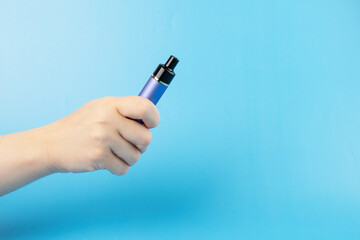vape reusable, electronic cigarette with replaceable cartridges in hand, copy space