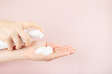 cleanser face foam, beauty skincare cosmetic in pump container in a woman's hand