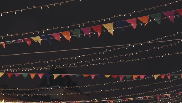 Merry Christmas and Happy New Year. Small flags and garlands over the Christmas Market at night