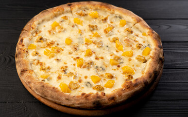 Sweet Gorgonzola pizza with honey and peach on wooden background.