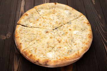 Pizza quattro formaggi slices on a wooden background. Cheese pizza