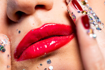 Close-up of woman with red lipstick touching face