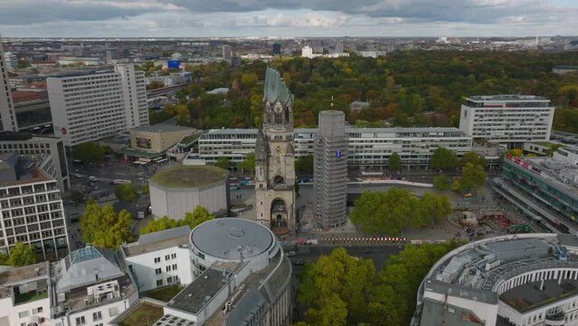 Aerial slide and pan footage of historic landmarks in modern urban borough. Remains of Kaiser Wilhelm Memorial Church. Charlottenburg neighbourhood, Berlin, Germany