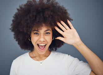 Hand, wave and excitement with an afro black woman in studio on a gray background greeting with a smile. Portrait, hair and happy with an attractive young female waving to welcome or say hello