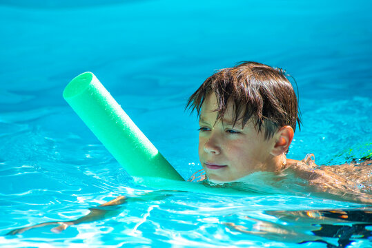 enfant avec une frite dans une piscine, apprentissage natation