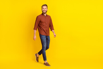 Fototapeta na wymiar Full body profile portrait of cheerful person have good mood walking isolated on yellow color background