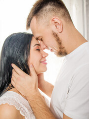tenderness of a man and a woman, a couple in love at home,Tender picture of young couple,Tender picture of young couple, Man kissing woman to forehead.