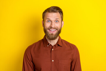 Portrait of optimistic ecstatic man with masculine beard wear burgundy shirt impressed staring at sale isolated on yellow color background