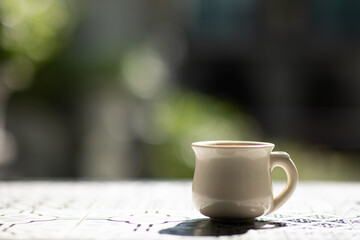 tea cup on wooden table beautiful green nature background