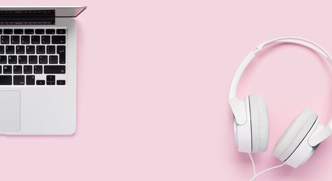 Headphones and laptop on pink