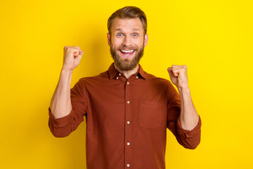 Photo of impressed crazy funny man with blond beard wear burgundy shirt clench fists up win bet...