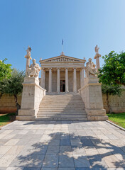 Fototapeta na wymiar The national academy's main facade with Socrates, Plato, Athena and Apollo marble statues. Culture travel in Athens, Greece.