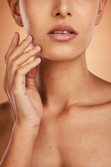 Hand, face and beauty with a model woman closeup in studio on a beige background for natural skincare. Wellness, luxury and cosmetics with a young female posing to promote a dermatology skin product