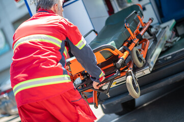 Paramedic taking a wheeled stretcher out of the EMS vehicle