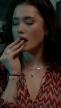 Brunette woman eating a piece of chocolate