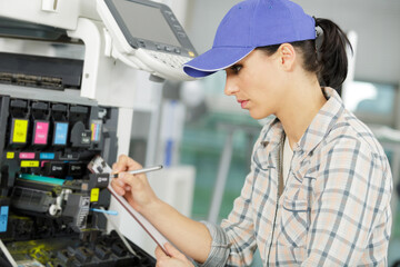 young female technician fixing a printer