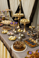 Table with cakes, sweets, candy, buffet. Dessert table for a party goodies for the wedding banquet area. Close up candy bar. Decorated delicious.