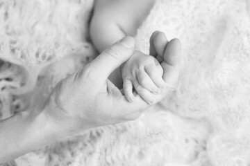 Newborn children's hand in mother hand. Mom and her Child. Happy Family concept. Beautiful conceptual image of Maternity