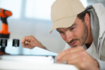 young repairman installing hob in kitchen