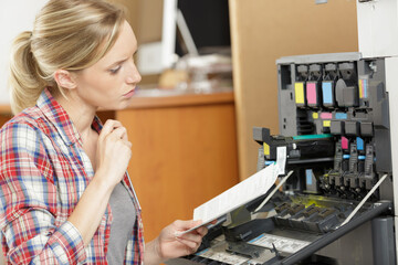 woman reading instruction manual for photocopier