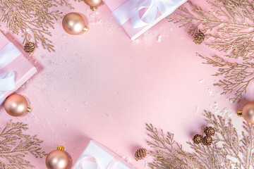 Rose gold Christmas, New Year background with golden christmas tree twigs and balls, holiday gift...