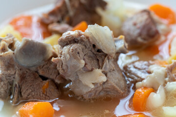 Boiled lamb meat with potatoes, carrots , onions, top view, copy space. Homemade winter comfort food.