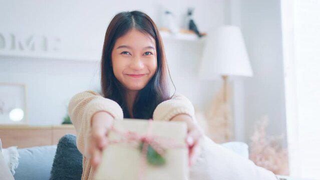 Giving a gift, Happy young asian woman giving handmade present wrapped paper. Christmas time. New Year's Eve and gift giving