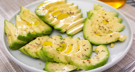 ripe avocado pulp cut into pieces sprinkled with lemon juice on a plate