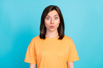 Fototapeta premium Photo of nice cute astonished girl with straight hairdo wear yellow t-shirt staring pouted lips kiss isolated on blue color background