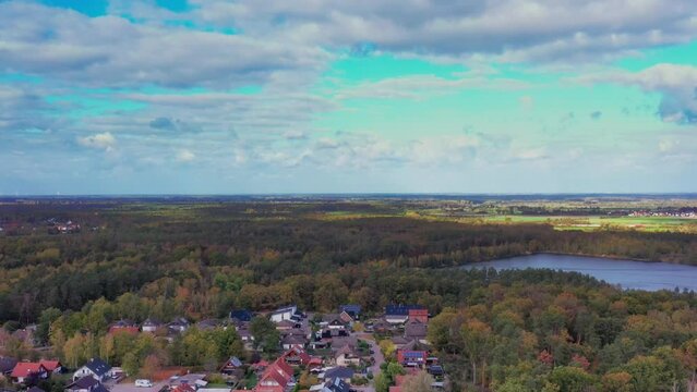 Aerial view looking to the flat horizon of the North German Plain with the edge of a suburb and a pond in the foreground