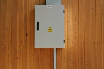 Knife switch and high voltage hazard sign on the wooden wall of house. Yellow electrical warning...