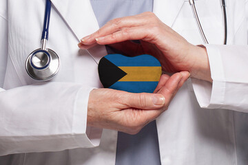 Bahamas doctor holding heart with flag of Bahamas background. Healthcare, charity, insurance and medicine concept