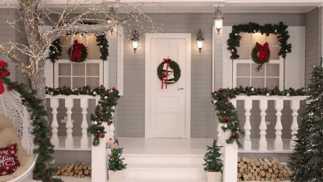 house christmas lights, decorated with garlands, Family time. Christmas and New Year decorating the interior of the living room, with a magic glow tree, gifts, decorated Christmas tree